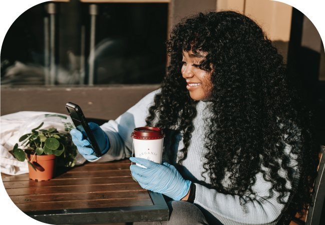 Woman uses SMS opt in on her mobile device while drinking tea